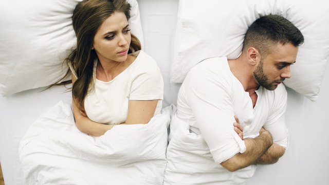 Top View Of Young Upset Couple Lying In Bed Have Problems After Quarrel And Angry Each Other At Home