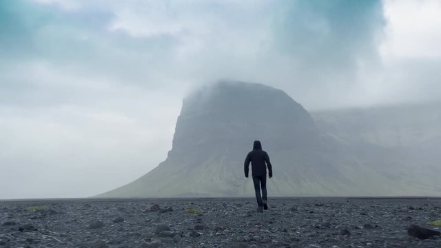 Aerial Flight Over Lonely Brave Man Figure Walking to Nordic Mountain Landscape Beautiful Fog Clouds Rain Loneliness Facing Challenge Bravery Concept