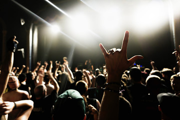 silhouettes of concert crowd in front of bright stage lights.