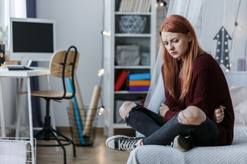 Young girl sitting on bed