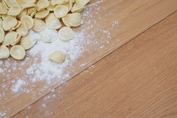 Fototapeta na wymiar Fresh orecchiette. Italian traditional pasta on wooden table with flour