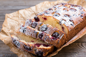 Slice of homemade cranberry cake with cherries and powdered sugar