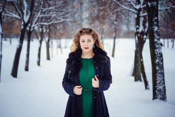 Young beautiful woman walking in a park and breathing fresh winter air and feeling wonderful