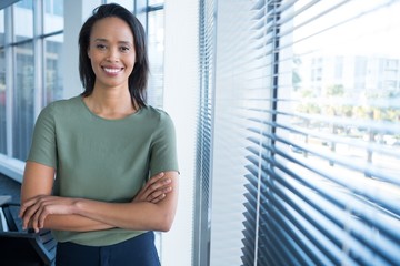 Portrait of female executive standing with arms crossed