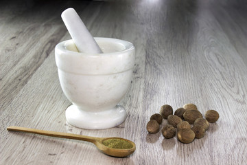 A mortar of nutmeg on a wooden table