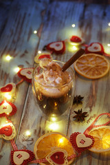 Christmas composition with thermo glass cup of tasty coffee topped with frothy milk and cinnamon powder served on rustic wooden table with xmas decoration 4