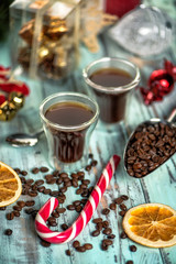 Black coffee in glass cups with christmas decoration and candies. light toned