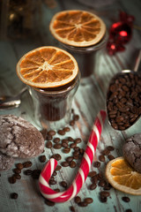 Black coffee in glass cups with christmas decoration and candies. Warm toned