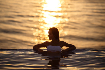 Fototapeta premium Woman Summer Fashion. Happy Sexy Smiling Girl With Fit Body, Long Legs, Healthy Skin In Bikini, Sunglasses Sunbathing By Swimming Pool On Travel Holidays Vacation. Beauty, Wellness, Lifestyle