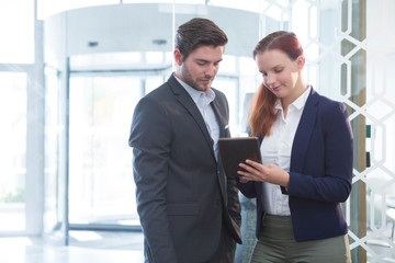 Business executives discussing over digital tablet