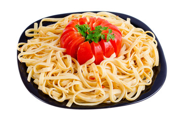 Pasta or spaghetti  or vermicelli lie on a plate along with a tomato and seasoning food