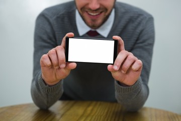 Executive showing mobile phone in the office