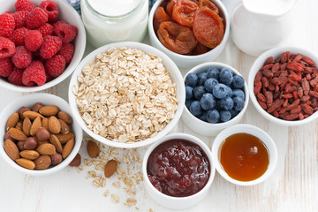 oat flakes and various delicious ingredients for breakfast, close-up, top view
