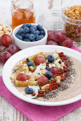 oatmeal with assorted fruits, nuts and chia, vertical