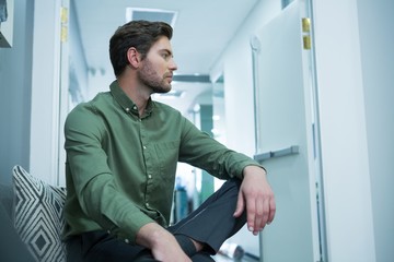 Male executive sitting on chair in waiting area