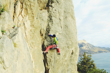Rock climber ascending a challenging cliff. Extreme sport climbing. Freedom, risk, challenge,...