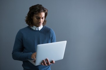 Male executive using laptop in office