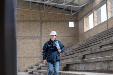 Senior construction manager controlling building site.