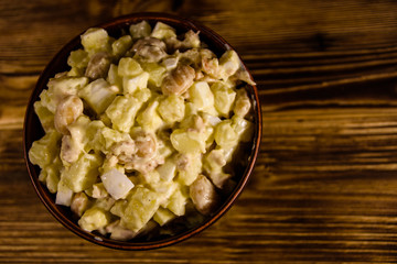 Salad with the haricot beans and meat dressed with mayonnaise in ceramic bowl. Top view