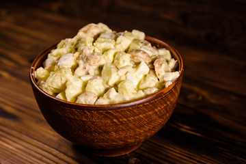 Salad with the haricot beans and meat dressed with mayonnaise in ceramic bowl