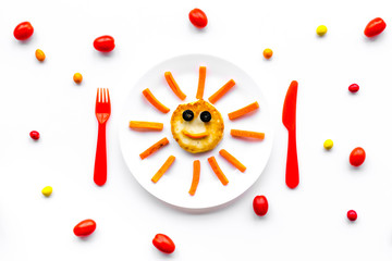 Creative approach to kid's braekfast. Meal with cheesecake in shape of sun. White background top view
