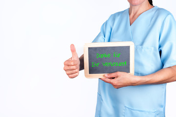 Ärztin mit Tafel in der Hand auf der steht Danke für Ihr Vertrauen