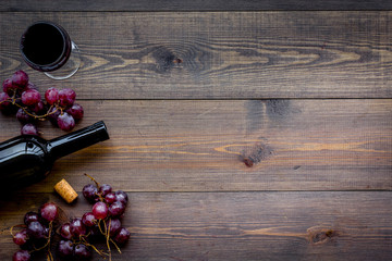 Drink wine concept. Bottle, glass, grape on wooden background top view copyspace