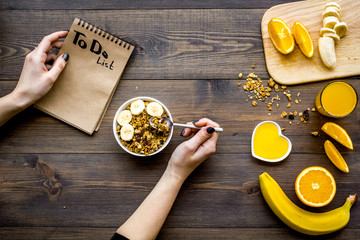 Good morning habits. Eat porridge and fruits and make to do list. Dark wooden background top view