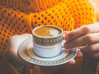 A Cup of coffee in the hands of a young girl. 

