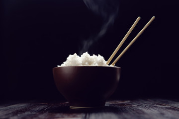 hot rice in brown bowl with chopsticks in japanese style