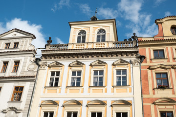 Fototapeta na wymiar Row of vernacular houses surrounding Old Town Square in Prague, Czech Republic. Looking up at traditional historic architecture in Prague. Dutch gabled roof and stone balcony. Bright sunny day.