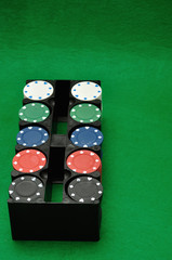 Poker chips displayed in a plastic black container with a green background