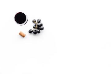 Tasting wine. Glass of beverage and grape on white background top view copyspace