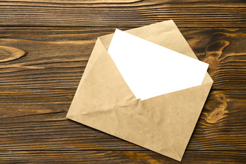 Envelope with card on wooden background