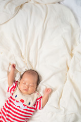 Asian baby boy wearing red Santa Claus outfit with reindeer hat.