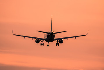 Airplane landing at sunset