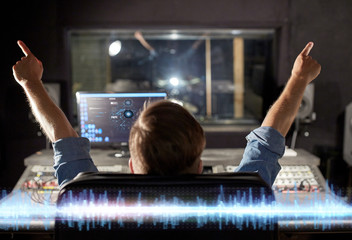 man at mixing console in music recording studio