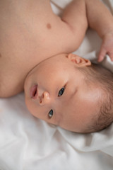 Asian new born baby boy smiling.