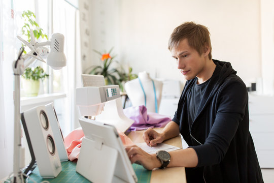 fashion designer with tablet pc working at studio