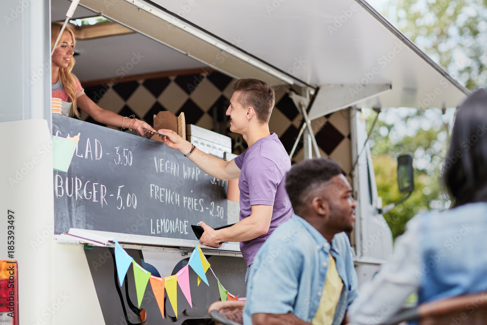 Poster customer paying money to saleswoman at food truck