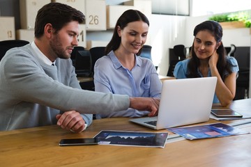 Executives discussing over laptop