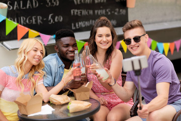 happy young friends taking selfie at food truck