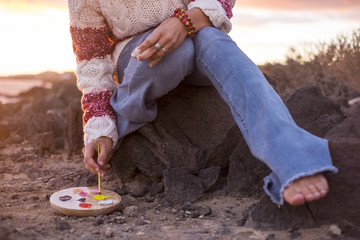 woman coloring mandala on stone