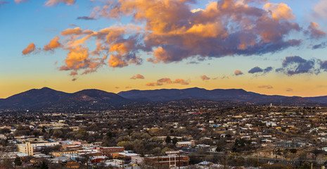beautiful clouds lit up for sunset over a small mountain town