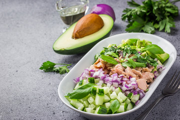 Sesame ginger avocado tuna cucumber salad on concrete background. Selective focus, copy space. 