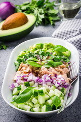 Healthy avocado tuna cucumber salad on concrete background. Selective focus, copy space. 
