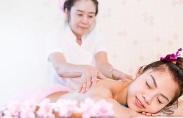 Obraz na płótnie Canvas Woman is receiving oil massage on the back in Thai Massage spa