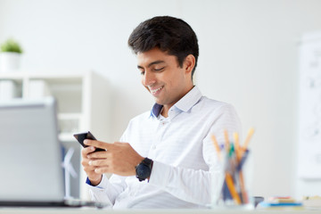 happy businessman with smartphone at office