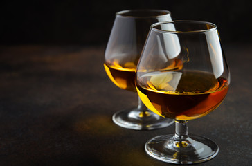 Glass of brandy or cognac on the old rusty background Selective focus Copy space