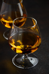 Glass of brandy or cognac on the old rusty background Selective focus
